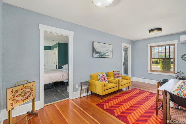 4196 S Pennsylvania St, Englewood, CO 80113 - living area featuring an AC wall unit, baseboards, and hardwood / wood-style floors