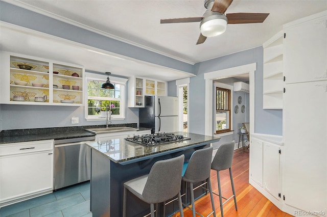 4196 S Pennsylvania St, Englewood, CO 80113 - kitchen with open shelves, appliances with stainless steel finishes, a breakfast bar, a sink, and a wall unit AC