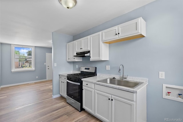 10911 W 44th Pl, Wheat Ridge, CO 80033 - kitchen with stainless steel range with gas stovetop, a sink, under cabinet range hood, light countertops, and white cabinetry