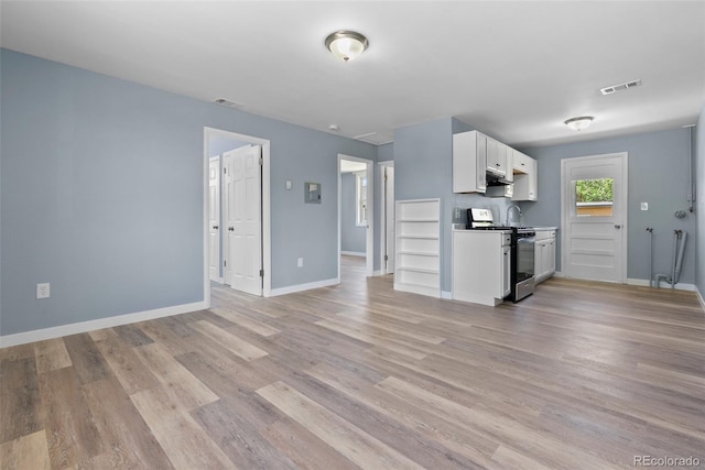 10911 W 44th Pl, Wheat Ridge, CO 80033 - kitchen with range with gas cooktop, white cabinetry, light wood finished floors, and baseboards
