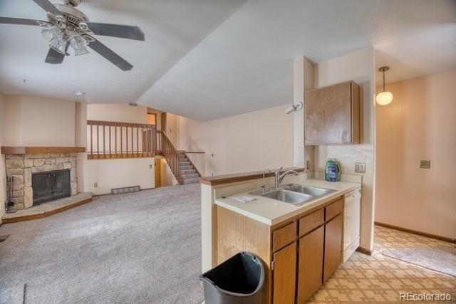 kitchen with lofted ceiling, a sink, open floor plan, light countertops, and dishwasher