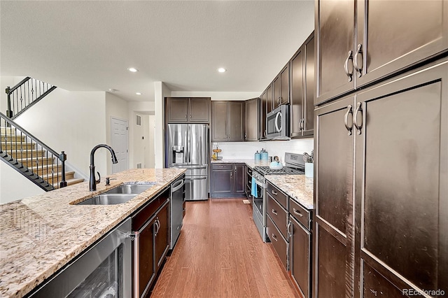 6335 E 143rd Dr, Thornton, CO 80602 - kitchen with stainless steel appliances, wood finished floors, dark brown cabinets, light stone countertops, and recessed lighting