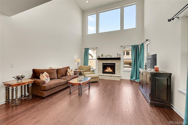 6335 E 143rd Dr, Thornton, CO 80602 - living area with a stone fireplace, dark wood-style flooring, and a high ceiling