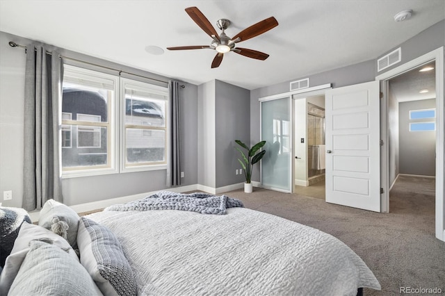 bedroom with ceiling fan, ensuite bathroom, carpet, and multiple windows