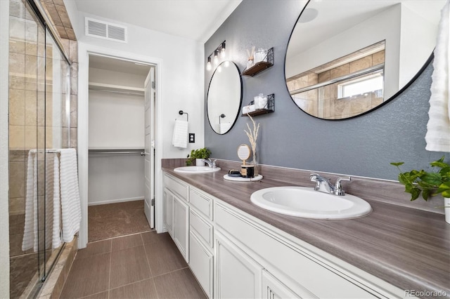 bathroom featuring vanity, an enclosed shower, and tile patterned flooring