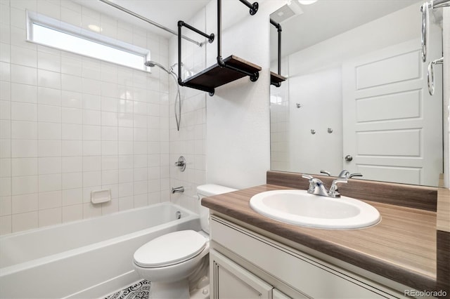 full bathroom featuring tiled shower / bath, vanity, and toilet