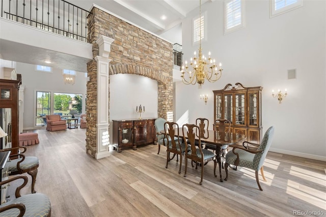 9151 E Harvard Ave, Denver, CO 80231 - dining space featuring a towering ceiling, a chandelier, ornate columns, light wood-style floors, and beamed ceiling