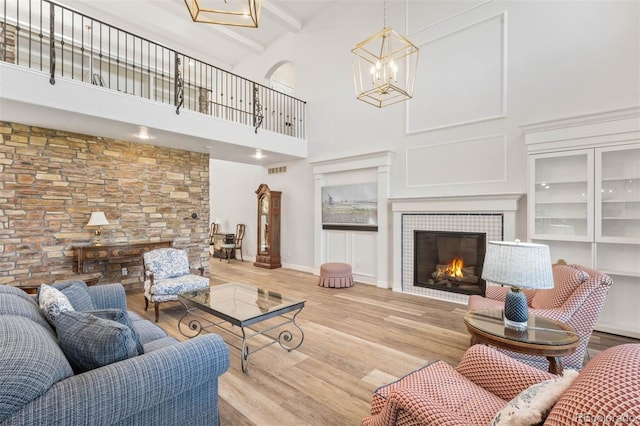 9151 E Harvard Ave, Denver, CO 80231 - living area featuring a towering ceiling, wood finished floors, a fireplace, and a chandelier