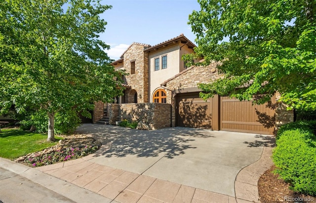 9151 E Harvard Ave, Denver, CO 80231 - view of front of house featuring stone siding, driveway, stucco siding, and a garage