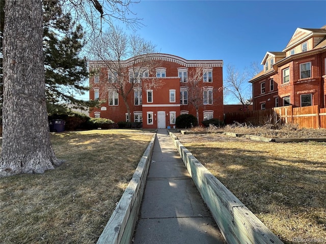 view of front of house featuring fence and brick siding