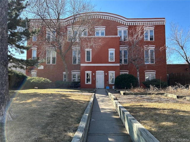 multi unit property featuring a front yard and brick siding