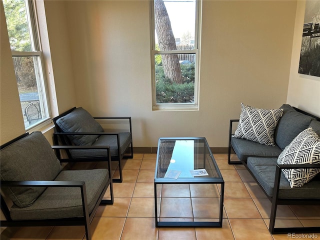 living room with baseboards, a wealth of natural light, and tile patterned floors