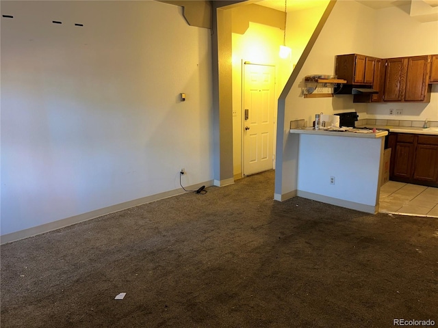 kitchen with light carpet, baseboards, pendant lighting, and light countertops