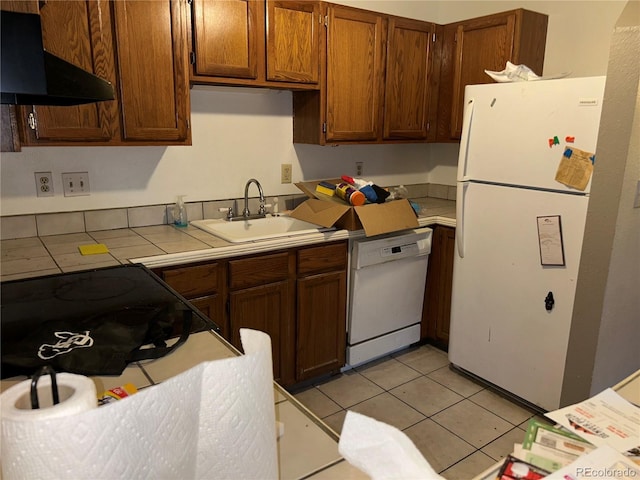 kitchen featuring light tile patterned floors, tile countertops, extractor fan, white appliances, and a sink