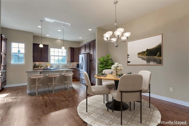 dining area with dark wood finished floors, recessed lighting, an inviting chandelier, and baseboards