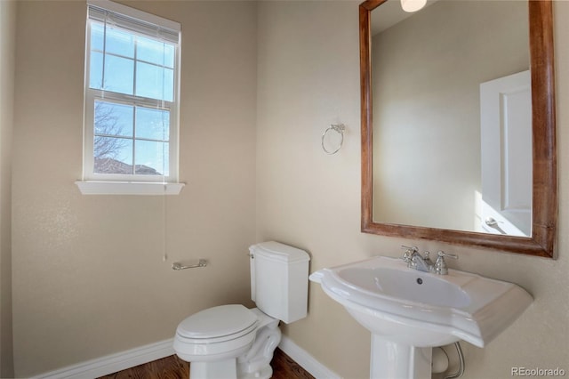 bathroom with baseboards, toilet, and a healthy amount of sunlight