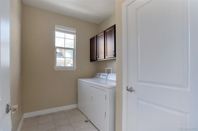 washroom featuring washer and dryer, light tile patterned floors, cabinet space, and baseboards