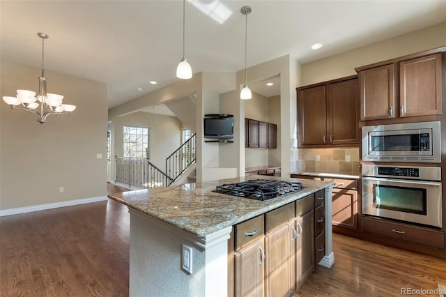 kitchen featuring light stone counters, stainless steel appliances, baseboards, and dark wood-style flooring