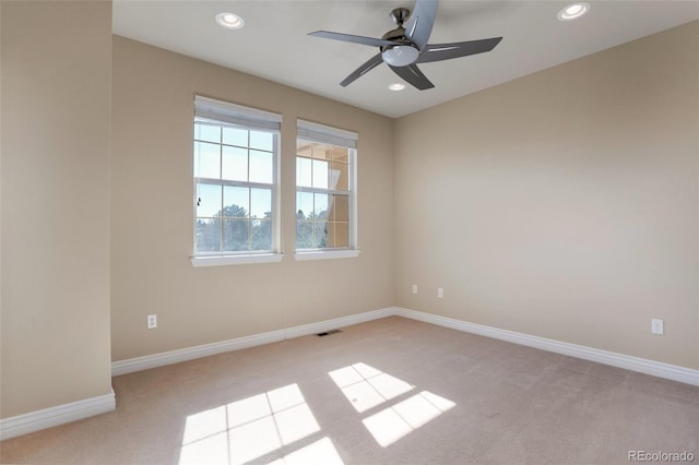 spare room with recessed lighting, baseboards, light carpet, and visible vents