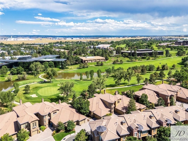 drone / aerial view with view of golf course, a residential view, and a water view