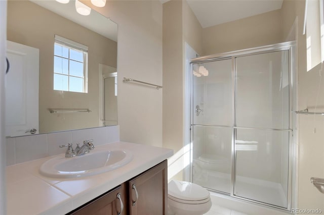 bathroom with vanity, a shower stall, and toilet