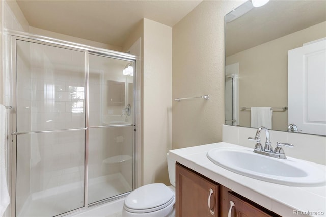 full bathroom featuring vanity, toilet, and a stall shower