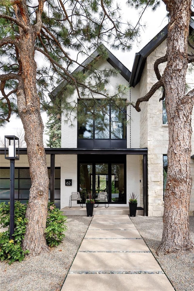 62 Jasmine St, Denver, CO 80220 - property entrance with brick siding, a porch, and stone siding