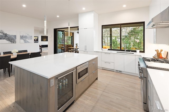 62 Jasmine St, Denver, CO 80220 - kitchen with modern cabinets, wall chimney exhaust hood, stainless steel appliances, white cabinetry, and recessed lighting