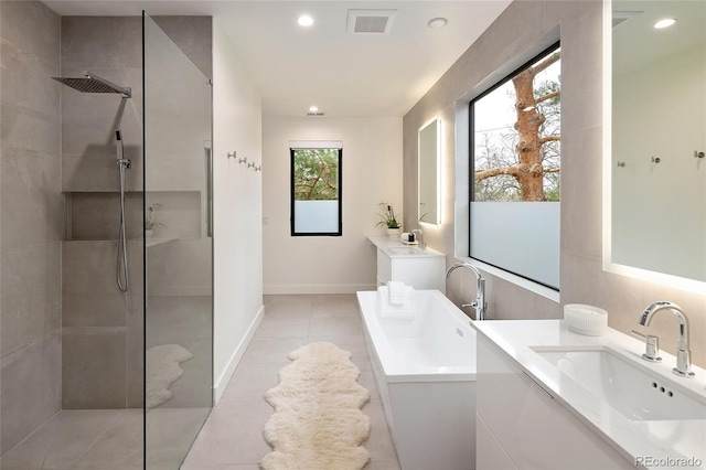 62 Jasmine St, Denver, CO 80220 - bathroom featuring a tub to relax in, walk in shower, two vanities, recessed lighting, and tile patterned floors