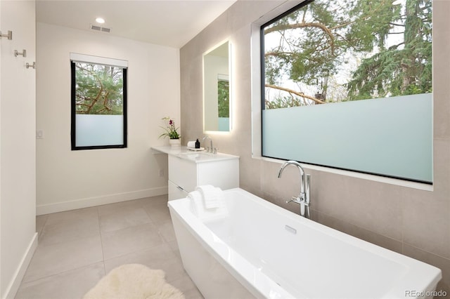 62 Jasmine St, Denver, CO 80220 - full bath featuring a freestanding tub, vanity, baseboards, tile patterned flooring, and recessed lighting