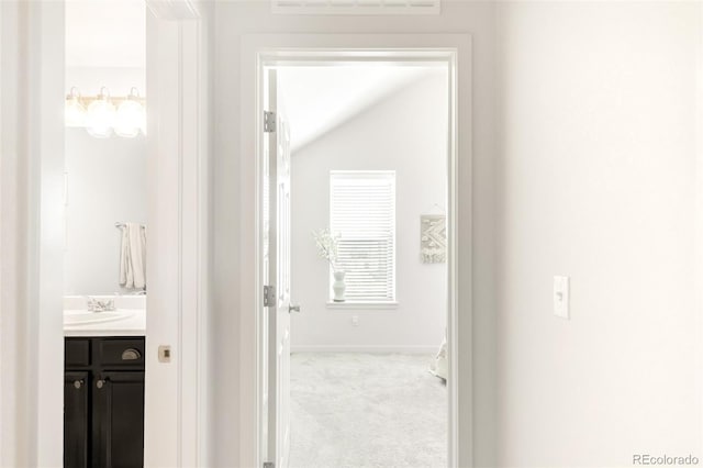 5025 Central Park Blvd, Denver, CO 80238 - hall featuring a sink, carpet flooring, baseboards, and vaulted ceiling