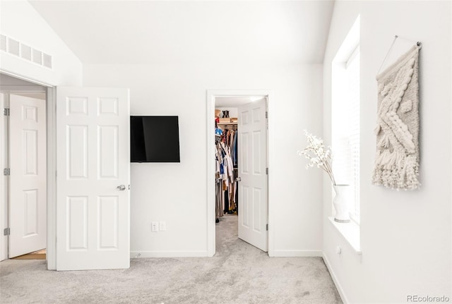 5025 Central Park Blvd, Denver, CO 80238 - unfurnished bedroom featuring a walk in closet, light colored carpet, a closet, lofted ceiling, and baseboards
