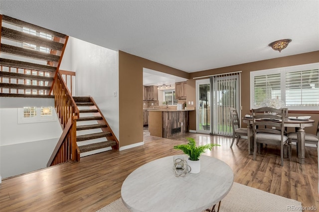 6119 Zenobia Ct, Arvada, CO 80003 - living area with wood finished floors, stairs, plenty of natural light, and a textured ceiling