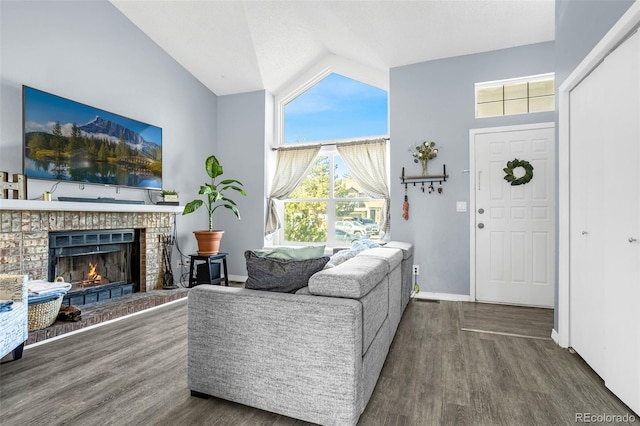 living area with a fireplace, wood finished floors, baseboards, and high vaulted ceiling