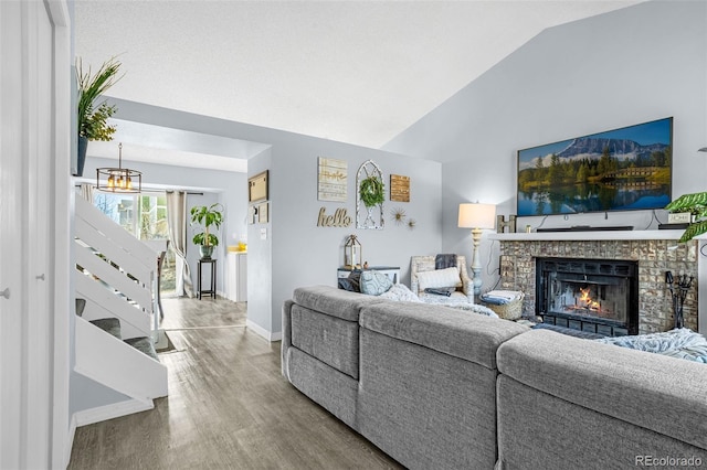 living room with a brick fireplace, baseboards, lofted ceiling, and wood finished floors