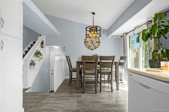 dining space with a chandelier, a textured ceiling, and wood finished floors