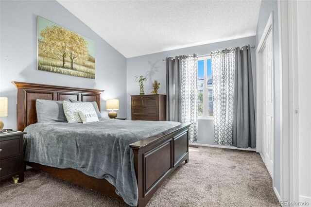 bedroom with lofted ceiling, carpet, and a textured ceiling