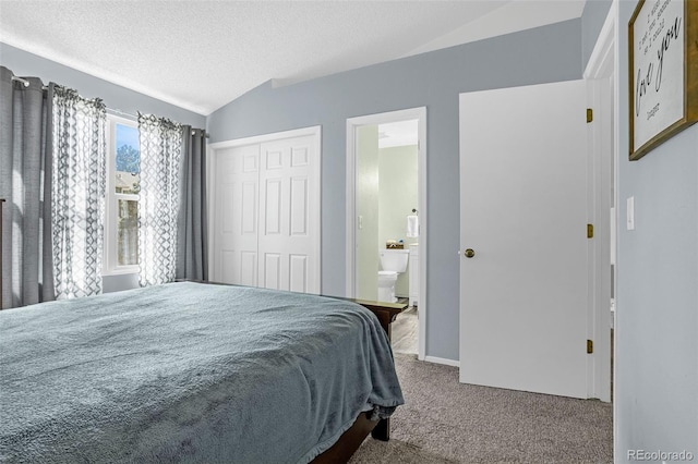 carpeted bedroom with a closet, connected bathroom, a textured ceiling, and lofted ceiling