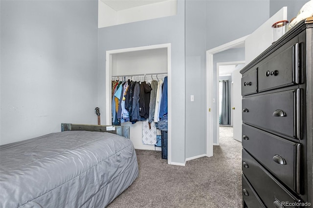 carpeted bedroom featuring baseboards and a closet