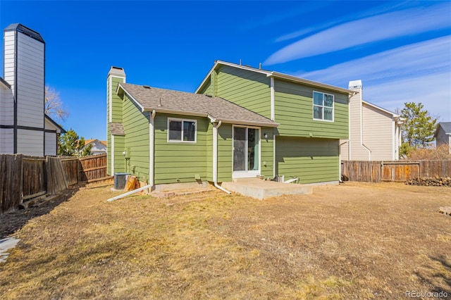 rear view of house with a patio, central air condition unit, and a fenced backyard