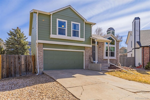 tri-level home featuring an attached garage, fence, brick siding, and driveway