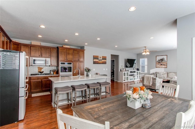 dining space featuring ceiling fan, dark hardwood / wood-style flooring, and sink