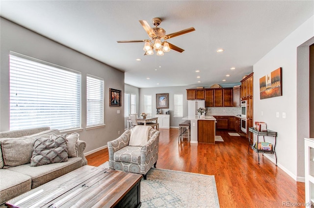 living room featuring dark hardwood / wood-style flooring and ceiling fan