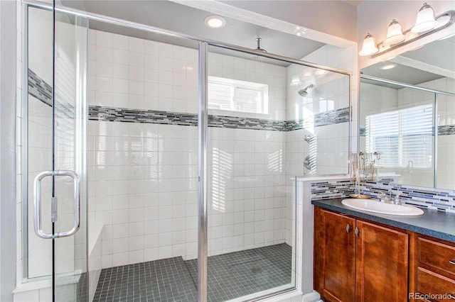 bathroom featuring tasteful backsplash, vanity, and walk in shower