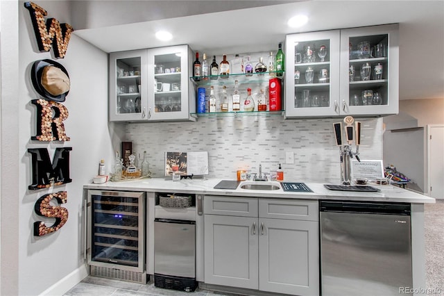 bar featuring sink, gray cabinetry, dishwasher, beverage cooler, and decorative backsplash