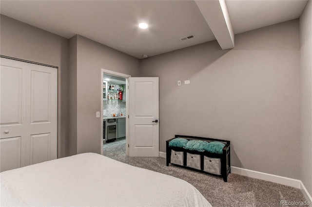 carpeted bedroom featuring beam ceiling, beverage cooler, a closet, and bar area