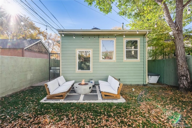 back of property featuring a lawn and an outdoor living space with a fire pit