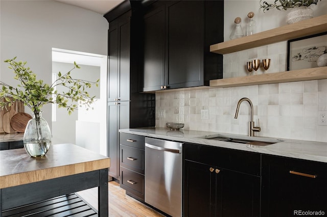 kitchen with sink, light hardwood / wood-style flooring, stainless steel dishwasher, decorative backsplash, and light stone counters