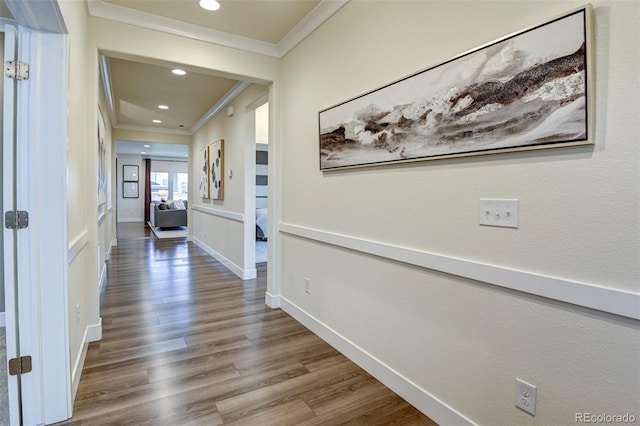 hall featuring baseboards, recessed lighting, wood finished floors, and crown molding