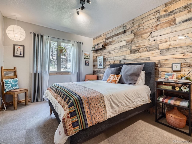 32663 Donna Dr, Conifer, CO 80433 - bedroom featuring wooden walls, carpet flooring, and a textured ceiling